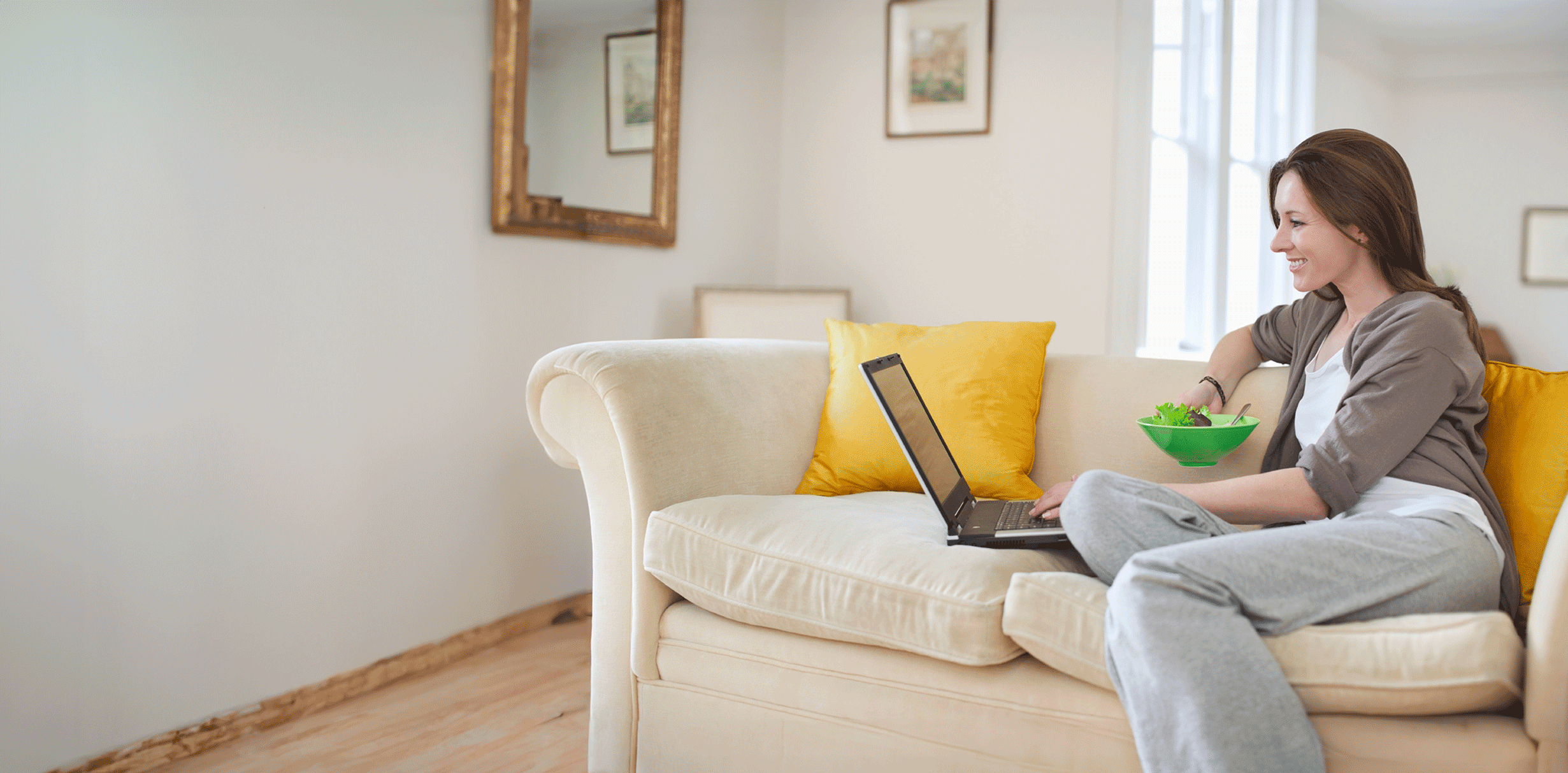 Woman on a couch using Internet Banking on her laptop.